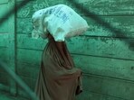 A woman in burqa walks with her belongings in Torkham, Pakistan.