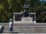 A woman walks near the statue of Russian Emperor Alexander III at the Livadia Palace in Yalta, Crimea.