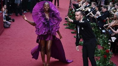 British TV presenter AJ Odudu stole the show Robert Wun purple gown featuring a high-low hem, floor-sweeping train, a frilled structure on the neckline, and a pleated design. She wore it with high heels and head-turning glam. (AFP) British TV presenter AJ Odudu stole the show Robert Wun purple gown featuring a high-low hem, floor-sweeping train, a frilled structure on the neckline, and a pleated design. She wore it with high heels and head-turning glam. (AFP)