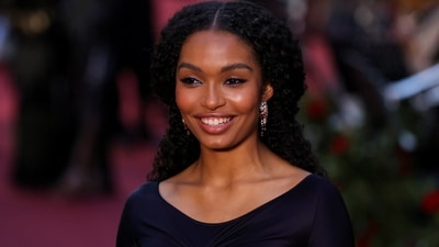 Yara Shahidi poses for a photo as she attends Vogue World in London, Britain. She chose a black Victoria Beckham gown featuring a figure-sculpting fit and a front slit. She wore it with high heels, fishnet stockings, earrings, and a dainty bracelet.&nbsp; (REUTERS)