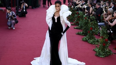 Winnie Harlow posed on the red carpet in a Zuhair Murad monochrome gown featuring a plunging neckline, a ruffled neckpiece attached on the back, and a floor-length train. She wore it with velvet Opera gloves, statement jewel pieces, and striking glam.&nbsp; (REUTERS)