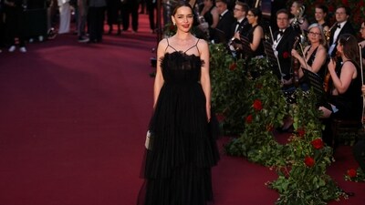 Emilia Clarke dazzled on the vogue World red carpet in black lace and tulle gown featuring spaghetti straps and cut-out details. The ensemble is from Dior. She styled it with Chopard jewels, ruby red lips, a centre-parted sleek bun, striking eye makeup, and a box clutch.&nbsp; (REUTERS)
