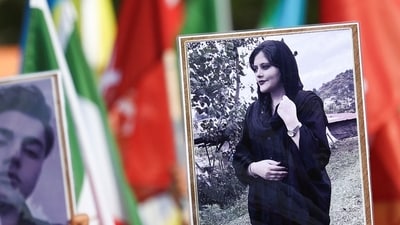 A person holds a picture of Mahsa Amini in a rally on the eve of the first anniversary of her death, (REUTERS)