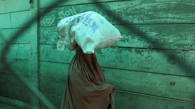A woman in burqa walks with her belongings in Torkham, Pakistan. (REUTERS representative)
