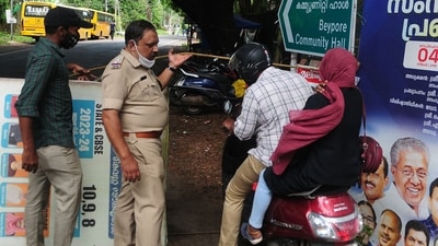 Police and health officials manning a road checkpoint let residents enter a containment zone following an increase of Nipah virus cases in Cheruvannur village of Kozhikode district in Kerala on September 16, 2023. (AFP) Police and health officials manning a road checkpoint let residents enter a containment zone following an increase of Nipah virus cases in Cheruvannur village of Kozhikode district in Kerala on September 16, 2023. (AFP)