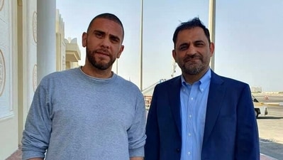 Iranians Reza Sarhangpour Kafrani, right, and Mehrdad Moein Ansari pose at Doha airport in Qatar after being released from prison in the United States in a prisoner swap with Iran. (AP)