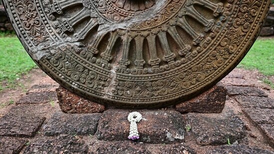 A prayer garland next to the 6th-9th Century B.C Dharmachakra artifact at the Si Thep historical site in Thailand's Phetchabun province. (AFP)