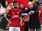 Manchester United's Dutch manager Erik ten Hag (R) gives instructions to Manchester United's Portuguese midfielder #08 Bruno Fernandes (L)