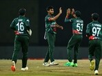 Bangladesh's Tanzim Hasan Sakib (2L) celebrates with teammates after taking the wicket of India's captain Rohit Sharma 