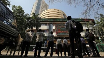 People look at a screen displaying the Sensex results on the facade of the Bombay Stock Exchange (BSE) building in Mumbai. (REUTERS)