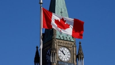 The Canadian flag flies in front of the Peace Tower on Parliament Hill in Ottawa, Ontario, Canada.