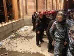 Law enforcement officers stand guard as protesters throw objects into the government building during a rally to support ethnic Armenians in Nagorno-Karabakh following Azerbaijani armed forces' offensive operation executed in the region.
