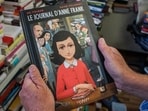 A man holds a copy of the graphic novel version of The Diary of Anne Frank, by Israeli writer-director Ari Folman and illustrator David Polonsky, in Paris on September 18, 2017.