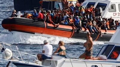 An Italian Coast Guard vessel carrying migrants rescued at sea passes between tourist boats, on the Sicilian island of Lampedusa, Italy, September 18, 2023. REUTERS/Yara Nardi (REUTERS)