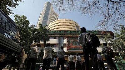 People look at a screen displaying the Sensex results on the facade of the Bombay Stock Exchange (BSE) building in Mumbai. (REUTERS)