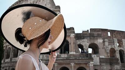 A tourist shelters from the sun with a panel as she walks past the Colosseum monument in Rome, on July 24 during a heatwave in Italy. (AFP) A tourist shelters from the sun with a panel as she walks past the Colosseum monument in Rome, on July 24 during a heatwave in Italy. (AFP)