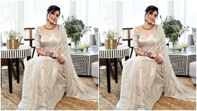 Styled by fashion stylist Saachi Vijaywargia, Karishma wore her tresses into a messy bun with white flowers adoring her hair. In nude eyeshadow, black eyeliner, black kohl, mascara-laden eyelashes, feathered eyebrows, contoured cheeks and a shade of nude lipstick, Karishma completed her look.&nbsp; (Instagram/@karishmaktanna)