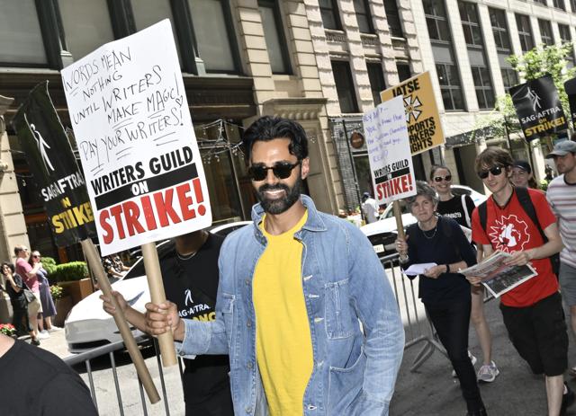 Hasan Minhaj carries a sign on the picket line outside Netflix on Friday, July 21, 2023, in New York. (Evan Agostini/Invision/AP) Hasan Minhaj carries a sign on the picket line outside Netflix on Friday, July 21, 2023, in New York. (Evan Agostini/Invision/AP)