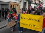 People march with a banner that reads, "no justice, no peace,"  in Paris.
