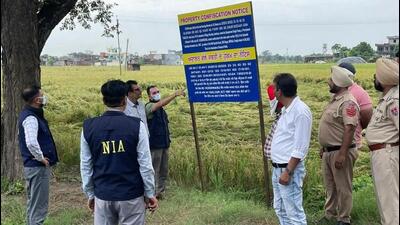 A National Investigation Agency (NIA) team after putting up a notice, confiscating 26 kanals of agricultural land, at Sikhs for Justice chief Gurpatwant Singh Pannu’s ancestral village of Khankot in Amritsar district on Saturday. (HT Photo) A National Investigation Agency (NIA) team after putting up a notice, confiscating 26 kanals of agricultural land, at Sikhs for Justice chief Gurpatwant Singh Pannu’s ancestral village of Khankot in Amritsar district on Saturday. (HT Photo)