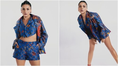 Shehnaaz wore a deep blue-coloured cropped waistcoat, jacket and shorts set decorated in floral patterns of red, mustard, yellow, green and bronze shades. (Instagram) Shehnaaz wore a deep blue-coloured cropped waistcoat, jacket and shorts set decorated in floral patterns of red, mustard, yellow, green and bronze shades. (Instagram)