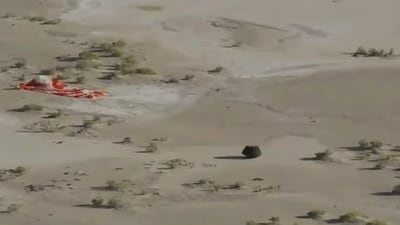 This image taken from video provided by NASA TV shows the capsule released by the Osiris-Rex spacecraft lying on the surface near the parachute after landing to Earth. (AP) This image taken from video provided by NASA TV shows the capsule released by the Osiris-Rex spacecraft lying on the surface near the parachute after landing to Earth. (AP)