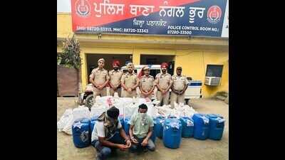 Two of the accused and the liquor recovered from them, in Pathankot on Sunday. (HT photo)