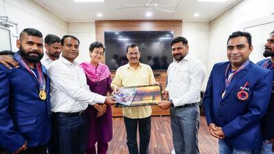 Delhi CM Arvind Kejriwal with para athletes who won medals at the International Dragon Boat Championship held in Thailand, in New Delhi on Monday. (HT Photo)