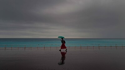 A woman shelters from heavy rainfall with an umbrella. (AFP) A woman shelters from heavy rainfall with an umbrella. (AFP)