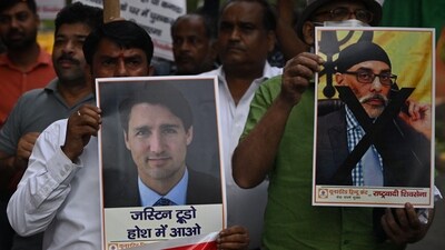 Members of United Hindu Front organisation hold banners depicting Justin Trudeau Canada's Prime Minister (L) and Gurpatwant Singh Pannun, a lawyer believed to be based in Canada designated as a Khalistani terrorist by the Indian authorities during a rally along a street in New Delhi on Sunday. (AFP)