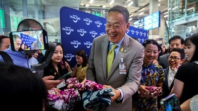 Thailand's Prime Minister Srettha Thavisin gives souvenirs to Chinese tourists during a welcome ceremony. (Reuters)