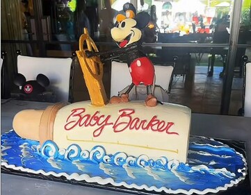 The highlight of the day was the custom ‘Baby Barker’ cake in the shape of a baby bottle with Mickey himself driving the boat on top.