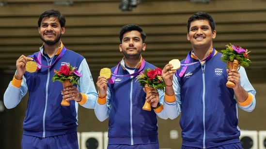 Indian shooters Rudrankksh Patil (right), Aishwary Pratap Singh Tomar (centre) and Divyansh Singh Panwar pose for photos with their gold medals during the presentation ceremony of Men's 10m Air Rifle team event at the 19th Asian Games(PTI)