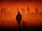 Migrants gather near the border wall after crossing the Rio Bravo (Source: Reuters)