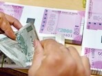 A bank staff member counts notes to give to customers. A bank staff member counts notes to give to customers.