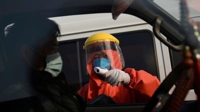 A worker in protective suit checks the temperature of a truck driver (Representational image)