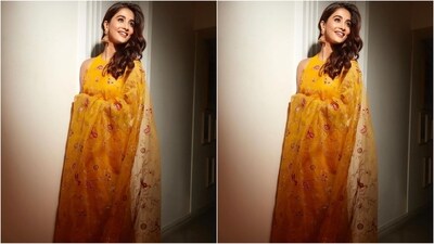 Her saree comes in an organza silk fabric and is intricately embroidered with birds and flower patterns all over in shades of gold and pink. She paired it with a yellow halterneck blouse. (Instagram/@hegdepooja) Her saree comes in an organza silk fabric and is intricately embroidered with birds and flower patterns all over in shades of gold and pink. She paired it with a yellow halterneck blouse. (Instagram/@hegdepooja)