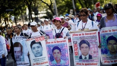 Demonstrators hold a protest to mark the 9th anniversary of the 43 Ayotzinapa Teacher Training College's students' disappearance, in Mexico City, Mexico September 26. (REUTERS)