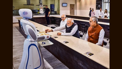 Prime Minister Narendra Modi, Gujarat Governor Acharya Devvrat and Chief Minister Bhupendra Patel being served tea by a robot at Science City, in Ahmedabad, Wednesday. (PTI) Prime Minister Narendra Modi, Gujarat Governor Acharya Devvrat and Chief Minister Bhupendra Patel being served tea by a robot at Science City, in Ahmedabad, Wednesday. (PTI)
