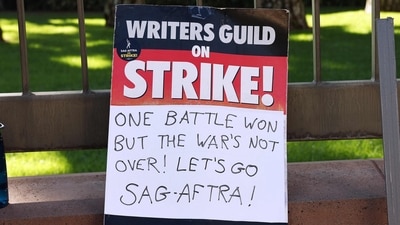 A WGA support sign rests near SAG-AFTRA members picketing outside Warner Bros. Studio (Photo by MARIO TAMA / GETTY IMAGES NORTH AMERICA / Getty Images via AFP) (Getty Images via AFP) A WGA support sign rests near SAG-AFTRA members picketing outside Warner Bros. Studio (Photo by MARIO TAMA / GETTY IMAGES NORTH AMERICA / Getty Images via AFP) (Getty Images via AFP)