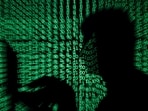 A man holds a laptop computer as cyber code is projected on him in this illustration picture
