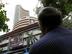 A man looks at a screen across a road displaying the Sensex on the facade of the Bombay Stock Exchange (BSE) building in Mumbai.