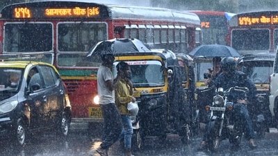 People crossing a road amid heavy rainfall in Andheri (Photo by Vijay Bate/HT Photo)