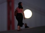 People walk on the roof of the Museum of Art, Architecture and Technology in Lisbon, as a full supermoon rises in the background, Thursday, Sept. 28, 2023. (AP Photo/Armando Franca) People walk on the roof of the Museum of Art, Architecture and Technology in Lisbon, as a full supermoon rises in the background, Thursday, Sept. 28, 2023. (AP Photo/Armando Franca)