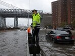 A police officer from the NYPD Highway Patrol looks on near cars stuck in a flooded motorway after heavy rains as the remnants of Tropical Storm Ophelia bring flooding across the mid-Atlantic and Northeast, at the FDR Drive in Manhattan near the Williamsburg bridge, in New York City, U.S., September 29, 2023. 