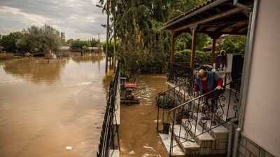 A local resident cleans the entrance of her house after the Storm Elias in village Sotirio, central Greece. (AFP) A local resident cleans the entrance of her house after the Storm Elias in village Sotirio, central Greece. (AFP)