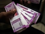 A cashier displays the new 2000 Indian rupee banknotes inside a bank