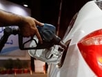 A worker holds a fuel nozzle to fills fuel in a car, after the government announced the increase of petrol and diesel prices, at petrol station in Karachi, Pakistan September 16, 2023.