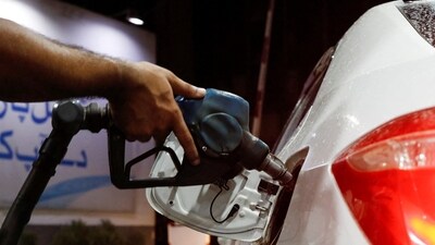 A worker holds a fuel nozzle to fills fuel in a car, after the government announced the increase of petrol and diesel prices, at petrol station in Karachi, Pakistan September 16, 2023. (REUTERS)