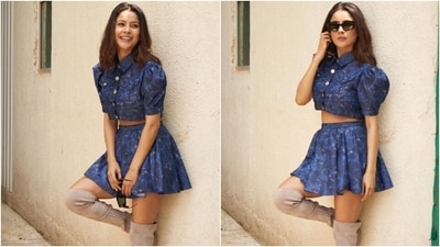 Shehnaaz's cropped blouse features a collared neckline, puffed half-length sleeves with cinched ends, gold button closures on the front, patch pockets on the bust, a fitted silhouette, and a short hem-length displaying her toned abs. (Instagram) Shehnaaz's cropped blouse features a collared neckline, puffed half-length sleeves with cinched ends, gold button closures on the front, patch pockets on the bust, a fitted silhouette, and a short hem-length displaying her toned abs. (Instagram)